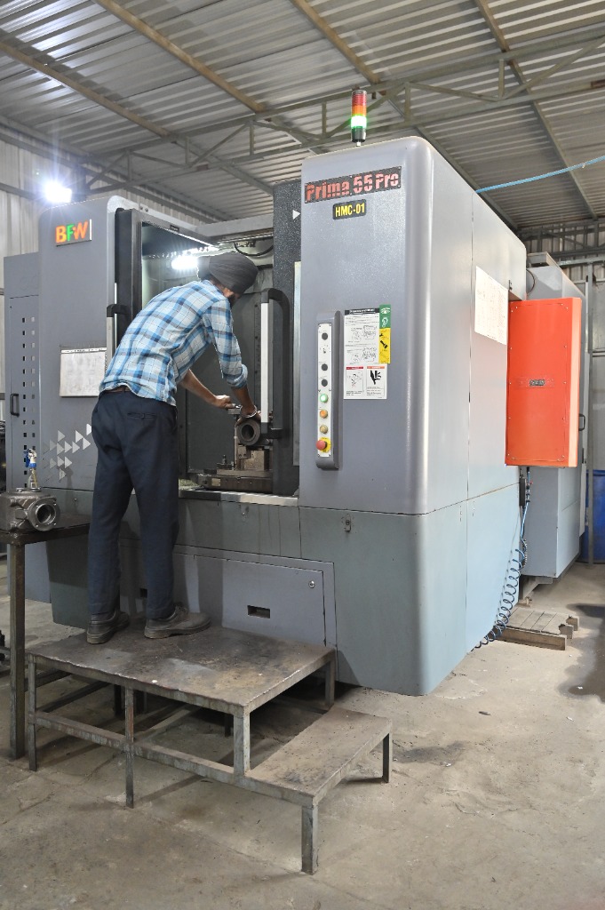 Experienced CNC operator setting up casting component in HMC-01 machine