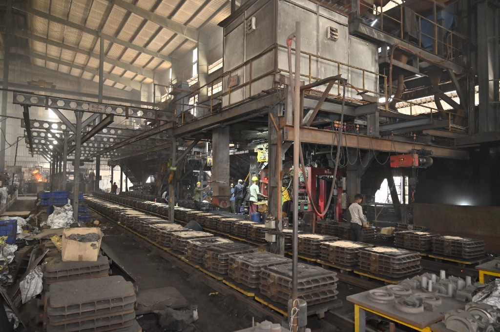 Panoramic view of automated mould box conveyor transport loops across the foundry floor