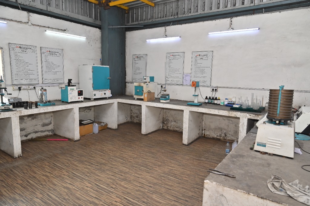 Panoramic view of the L-shaped laboratory table setup and sand quality testing instruments